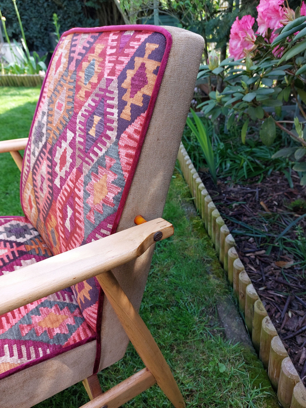 Vintage Sessel neu gepolstert im Boho-Stil, warme Farbtönte, helles Holzgestell, Detailansicht Keder in weinroter Farbe und Holz