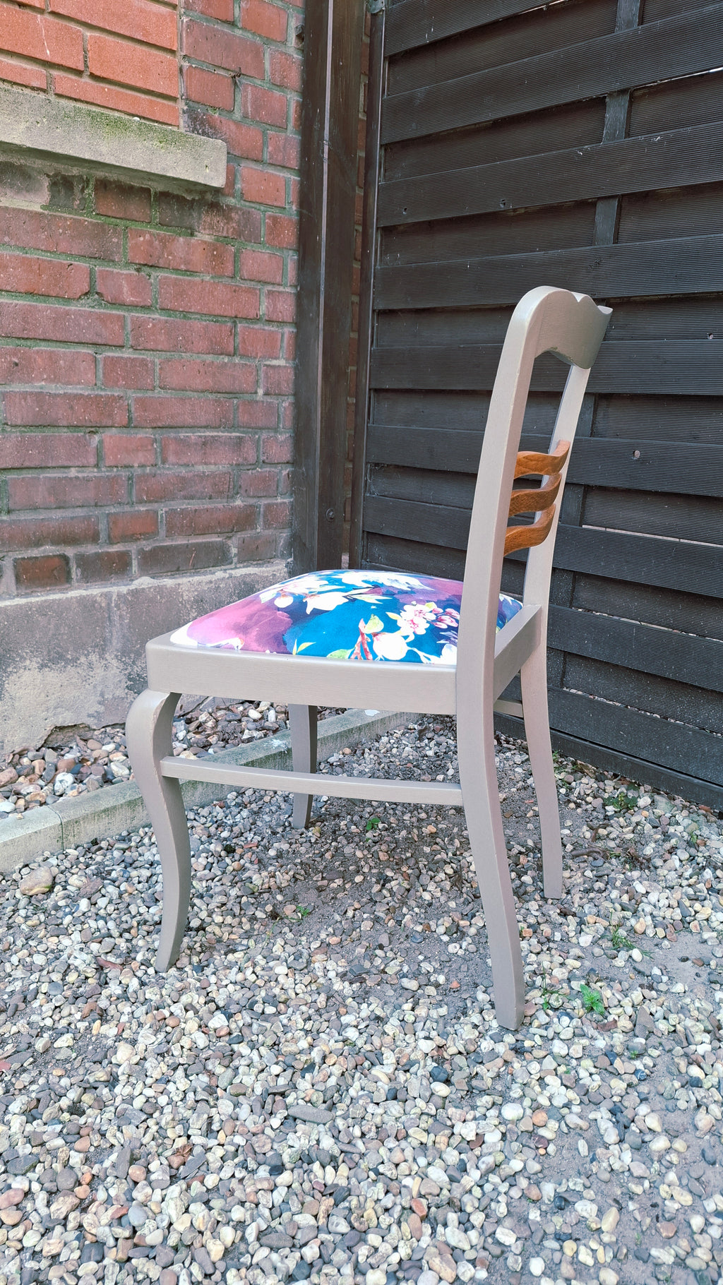 Alter Stuhl komplett aufgearbeitet, hellgraues Holzgestell mit naturbelassenen Holdetails auf der Rückenlehne, Sitz mit Veloursstoff bezogen mit Blumen und Kranichmuster, Seitenansicht links