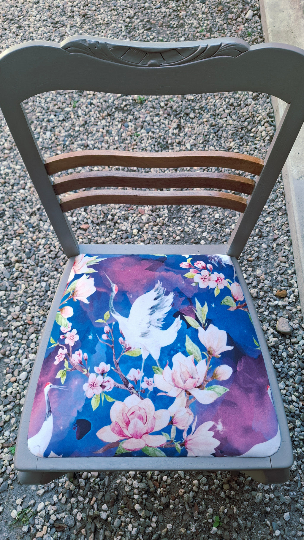 Alter Stuhl komplett aufgearbeitet, hellgraues Holzgestell mit naturbelassenen Holdetails auf der Rückenlehne, Sitz mit Veloursstoff bezogen mit Blumen und Kranichmuster, Detailansicht Muster auf dem Sitz