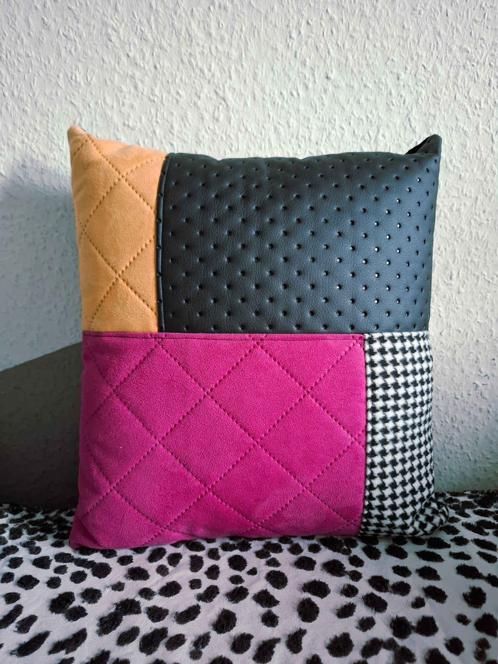 Einzelnes Patchwork-Dekokissen Kissen 1 – Nahaufnahme mit Magenta-Wildleder, Gelbem Wildleder, Hahnentritt-Muster und perforiertem schwarzem Kunstleder