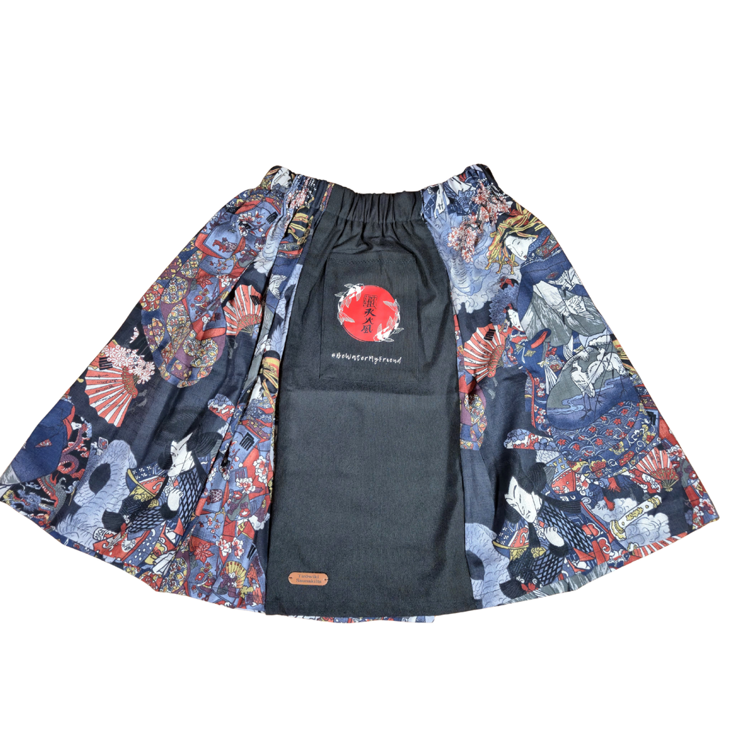 Hanzo Aufguss Art Kilt für Saunameister, japanisches Muster mit Samuraj, Kranichen und Fächern, vorne ein schwarzer Streifen mit einer kleinen Tasche drauf, auf der Tasche das Hanzo Logo, unten ein kleines Logoetikett von Tiröwiki, Vorderansicht Gesamtansicht ohne Hintergrund