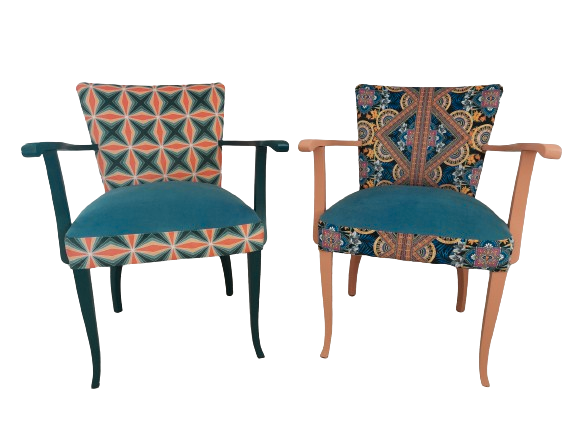 2 bunte Vintagestühle mit Armlehnen, Sitze blau gepolstern, links Retro-Muster blau orange, dunkelblaues Holzgestell, rechts Orient-Muster blau-orange, helloranges Holzgestell, Frontansicht
