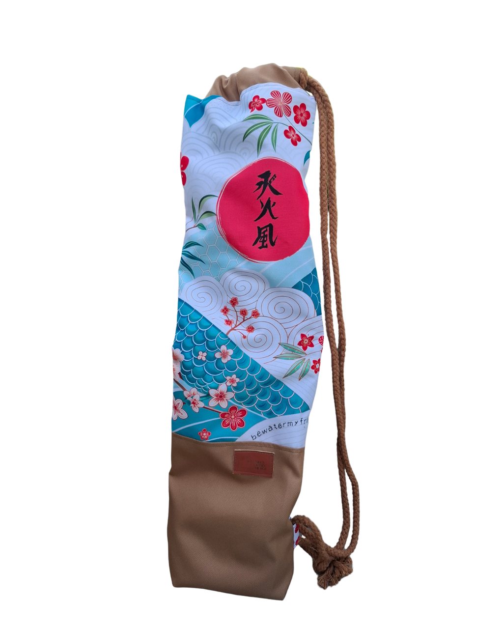 Hanzo Auguss Art Kellentasche für Saunakellen, oben buntes klassiches japanisches Muster mit den 3 Hanzo Kanji, unten Stoff in Karamell mit einem Things Outside The Box Lederetikett. Vorderansicht ohne Hintergrund
