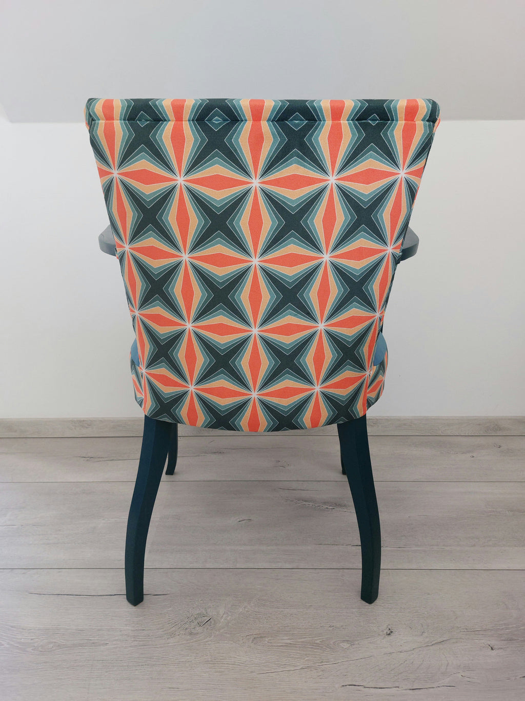 Bunter Vintagestuhl mit Armlehnen, Sitz blau gepolstert, Retro-Muster blau orange, dunkelblaues Holzgestell, Rückenlehne von hinten
