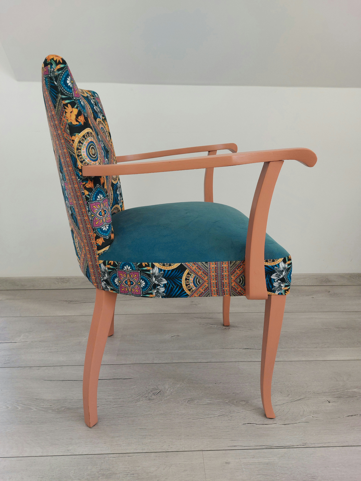 Vintagestuhl mit Armlehnen, Sitz blau gepolstert, Orient-Muster blau-orange, helloranges Holzgestell, Seitenansicht