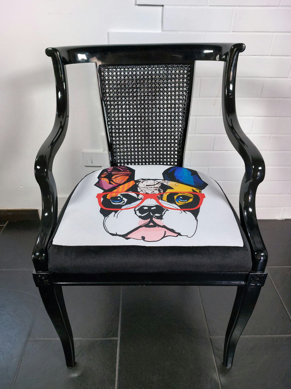 Sitzkissen mit buntem Comic-Print auf schwarzem Armlehnstuhl, Nahaufnahme