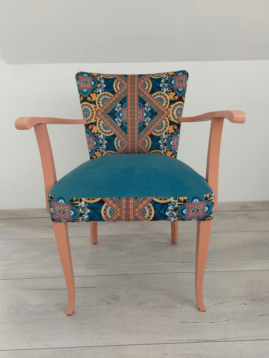 Vintagestuhl mit Armlehnen, Sitz blau gepolstert, Orient-Muster blau-orange, helloranges Holzgestell, Frontalansicht