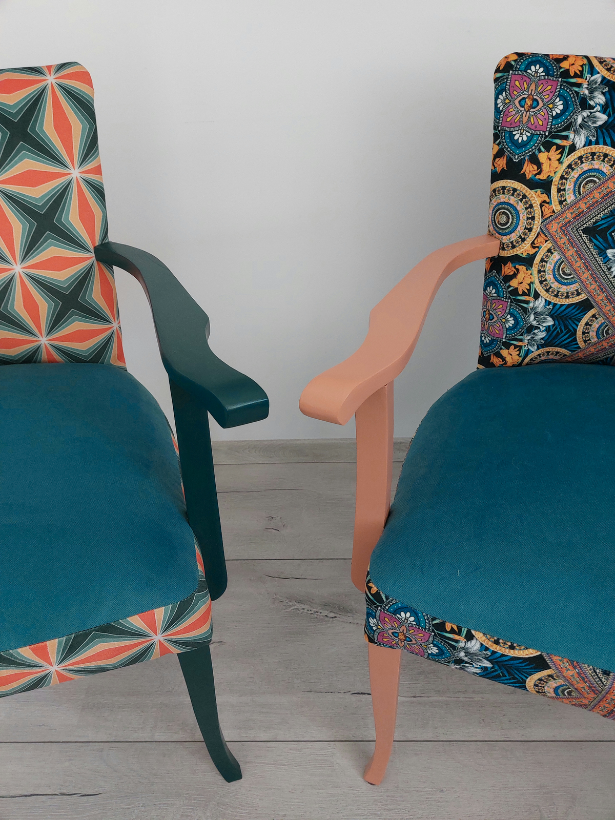 2 bunte Vintagestühle mit Armlehnen, Sitze blau gepolstern, links Retro-Muster blau orange, dunkelblaues Holzgestell, rechts Orient-Muster blau-orange, helloranges Holzgestell, Detailansicht Armlehnen und Beine