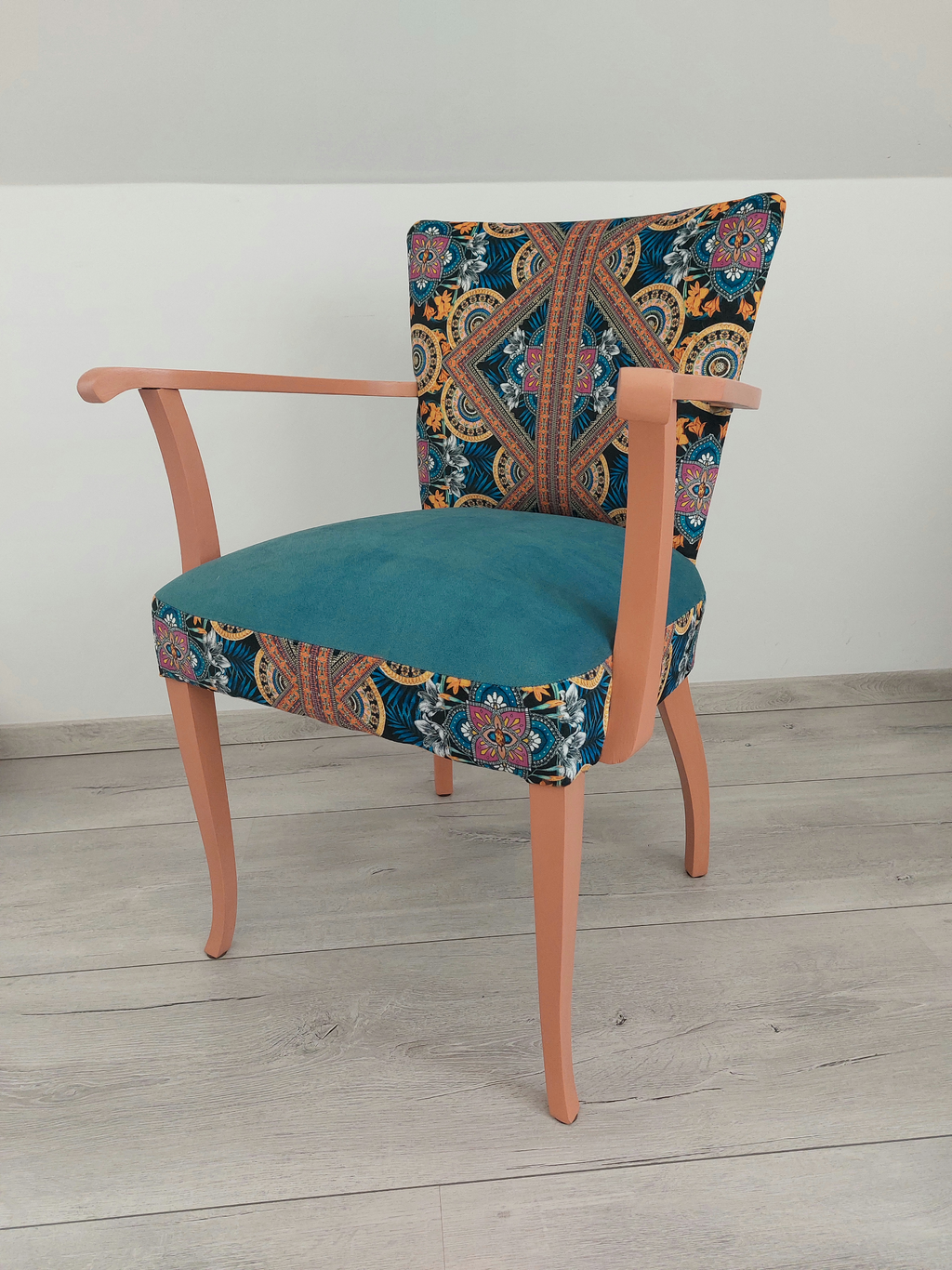 Vintagestuhl mit Armlehnen, Sitz blau gepolstert, Orient-Muster blau-orange, helloranges Holzgestell, Seitenansicht rechts