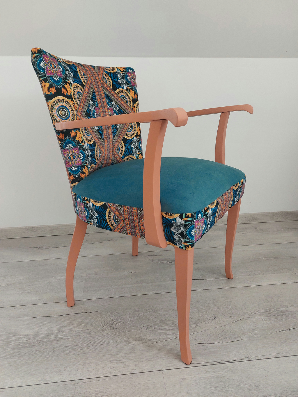 Vintagestuhl mit Armlehnen, Sitz blau gepolstert, Orient-Muster blau-orange, helloranges Holzgestell, Seitenansicht links